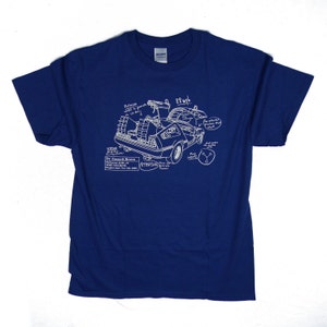 Puede incluir: Una camiseta azul con un contorno blanco de la máquina del tiempo DeLorean de la película Regreso al futuro. El diseño incluye el texto "Doc Emmett Brown, DeLorean DMC-12, Time Machine, Project Date: Nov 5th 1985, Attention: 1.21 Gigawatts".