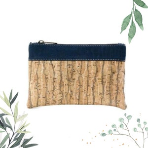 May include: A small, rectangular cork and blue suede zippered pouch. The pouch has a cork exterior with a natural wood grain pattern and a blue suede top flap.