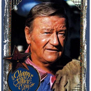 May include: A vintage-style card with a photo of John Wayne, a blue star, and a gold-lettered "Happy Father's Day" greeting on a blue circle.