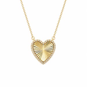 May include: A gold heart-shaped pendant necklace featuring a sunburst-textured center and a border of small clear stones. The pendant hangs from a delicate gold chain, creating a classic piece of jewelry with a polished finish and radiant design.
