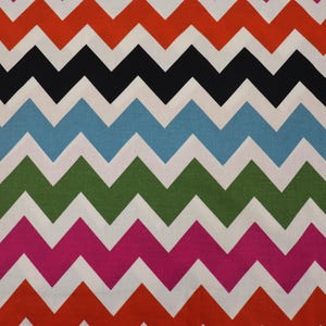 May include: A colorful chevron pattern fabric with alternating stripes of red, black, blue, green, pink, and white.