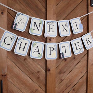 May include: A banner with the words "Her Next Chapter" in black letters on light blue and white rectangular cards. The banner is decorated with small illustrations of books, glasses, and floral accents. The banner is hanging against a wooden door.