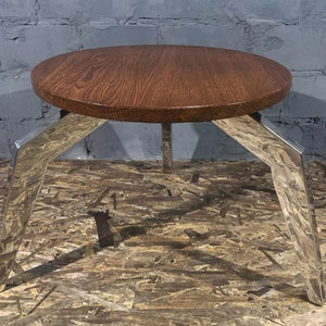 Modern oak coffee table with unique polished stainless steel legs. Round metal coffee table.