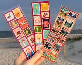 May include: Three rectangular bookmarks featuring colorful grid patterns of postage stamp illustrations. The designs include nature motifs like animals, flowers, and national park landscapes with various vibrant colors and detailed graphic artwork.