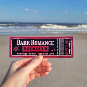May include: A red and black ticket with the text "Dark Romance Bookclub" and "Red Flags, Power, Forbidden Love". The ticket also has the text "Booklover" and "Admit One".