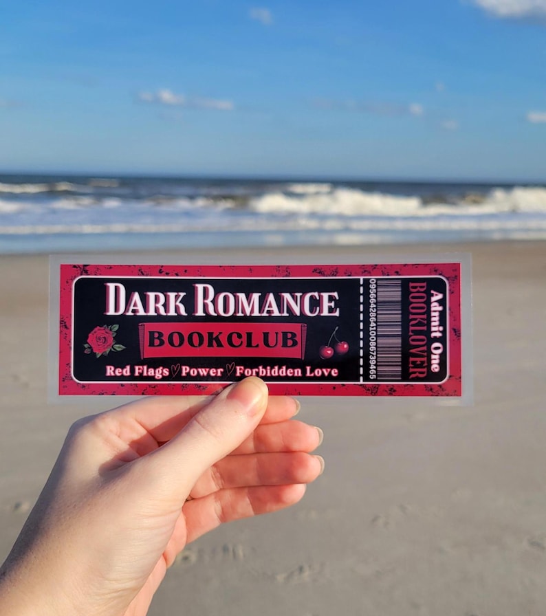 May include: A red and black ticket with the text "Dark Romance Bookclub" and "Red Flags, Power, Forbidden Love". The ticket also has the text "Booklover" and "Admit One".