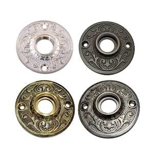 May include: Four decorative door knob escutcheons in different finishes: polished nickel, oil rubbed bronze, antique brass, and satin nickel. Each escutcheon features a detailed floral design.