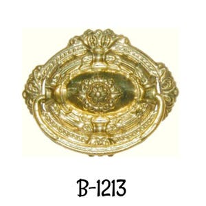 May include: A gold-toned, ornate, oval-shaped cabinet pull with a decorative floral design. The pull has a loop handle and is labeled "B-1213".