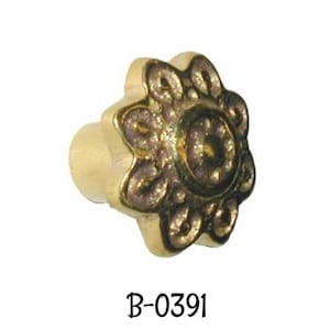 Peut inclure: Un bouton en métal doré avec un motif floral détaillé. Le bouton a une base ronde et un centre orné en relief.