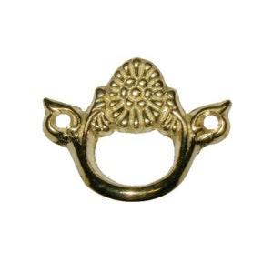 May include: Gold-toned metal decorative hardware with a floral design. The hardware has a loop for hanging or attaching.