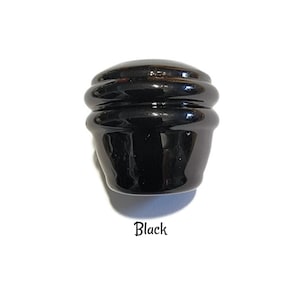 May include: Black ceramic knob with a rounded, layered design.
