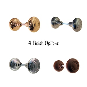 May include: Four door knobs in different finishes: gold, brushed nickel, chrome, and dark brown. Each knob has a round, ridged design. The text "4 Finish Options" is displayed below the knobs.