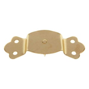 May include: Gold-toned metal buckle with a decorative design. The buckle has two holes on each side and a pointed tip in the center.