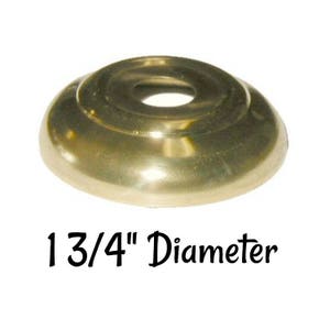May include: A gold-toned metal cap with a 1 3/4 inch diameter. The cap has a raised edge and a smooth, rounded surface.