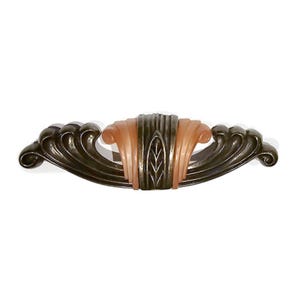 May include: An Art Deco style cabinet pull with a bronze finish and a central peach-colored accent. The pull features a stylized leaf design and curved wave-like edges, creating a vintage aesthetic.