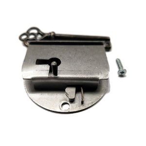 May include: A silver-toned metal lock with a keyhole and a decorative key. The lock has a round base and a rectangular top. A small silver screw is also included.
