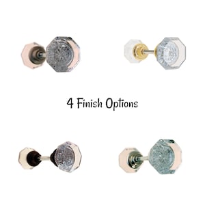May include: Four different finishes of a glass door knob with a octagonal shape. The knob is shown with a metal rod connecting two knobs.