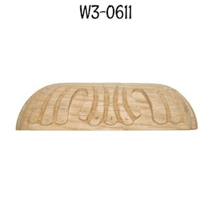 May include: A light wood cabinet pull with a carved design. The pull is shaped like a half-circle and has a smooth, rounded edge. The pull is labeled "W3-0611".