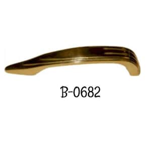 May include: A gold-toned metal cabinet door pull with a curved design and a raised centre section. The pull is labelled "B-0682".