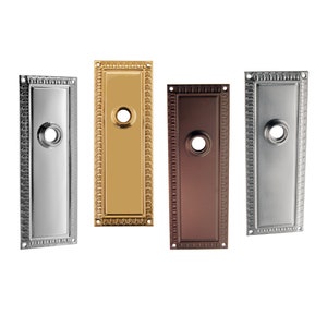 May include: Three door hardware plates in different finishes: silver, gold, and bronze. Each plate has a decorative border and a keyhole.