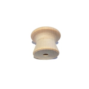May include: A single, unfinished wooden cabinet knob. The knob has a rounded top and a flared, hourglass-shaped body. A small hole is drilled into the bottom for mounting. The wood grain is visible.
