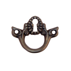 May include: Antique-style keyhole escutcheon with a decorative floral design. The escutcheon is made of metal and has a dark brown finish.