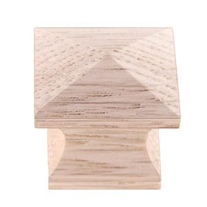 May include: A square wooden cabinet knob with a pyramid-shaped top. The knob is a light wood color with a natural wood grain.