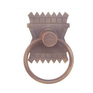 May include: A decorative brass ring pull with a detailed design. The ring pull has a square base with a decorative top and a round ring.