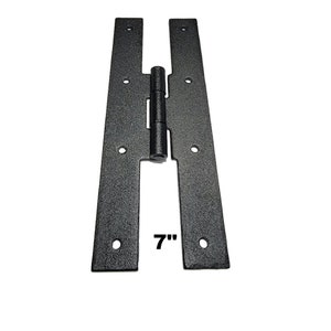 May include: Black metal hinge with a 7-inch length. The hinge is made of two flat pieces connected by a central pin.