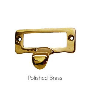 May include: Polished brass drawer pull with a rectangular label holder.
