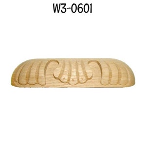 May include: A wooden, unfinished, decorative trim piece with a carved design. The trim is shaped like a half-oval and has a repeating pattern of stylized leaves. The trim is labeled "W3-0601".