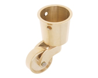 May include: Brass furniture caster with a round wheel and a cup-shaped top. The caster is designed to be attached to furniture legs.