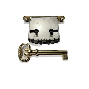 May include: A gold-colored key with a decorative head and a silver-colored lock with a keyhole.