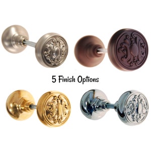 May include: Five different finishes of a decorative door knob with a round, ornate design. The finishes include polished nickel, oil rubbed bronze, polished brass, satin nickel, and polished chrome.