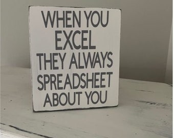 May include: White wooden sign with the text "When you excel they always spreadsheet about you".