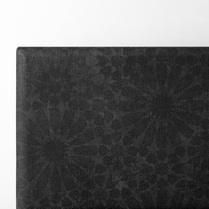 May include: Close-up of a black headboard with a textured fabric. The fabric has a subtle pattern of small, irregular shapes.