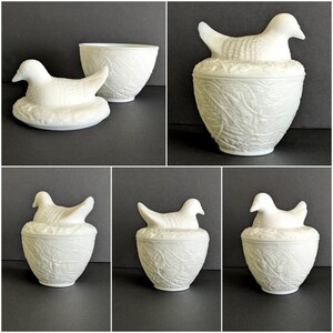 Puede incluir: Caja de baratijas de cer&aacute;mica blanca con tapa en forma de p&aacute;jaro. La caja tiene un patr&oacute;n de hojas detallado y un p&aacute;jaro posado en la parte superior. El p&aacute;jaro es blanco y tiene un dise&ntilde;o detallado. La caja probablemente se usa para guardar objetos peque&ntilde;os.