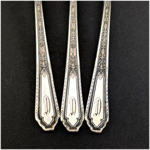 May include: Three silver forks with ornate designs and the letter "D" engraved on the handle.