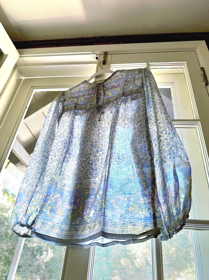 Vintage India Shirt In Featherweight Sheer Cotton Gauze With Pale Floral Print + Ethereal Balloon Sleeves | Deadstock. never been worn vintage Indian peasant blouse in pastel blues and violets. vintage Indian blouse. deadstock vintage India top. sheer cotton gauze India blouse. balloon sleeve India shirt. featherweight Indian gauze blouse. rare deadstock vintage India blouses. hand printed cotton Indian shirts.