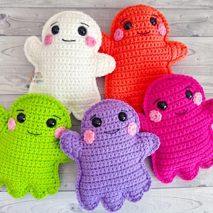 May include: Five handmade crochet ghost dolls in various colors: white, orange, pink, green, and purple. Each ghost has black eyes, a smiling mouth, and pink blush. The dolls are soft and plush, perfect for Halloween or as a cute decorative item.