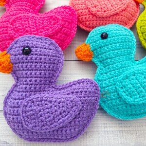 Peut inclure: Cinq canards en crochet de diff&eacute;rentes couleurs&nbsp;: violet, rose, turquoise, vert et orange. Les canards sont tous tourn&eacute;s dans la m&ecirc;me direction et sont dispos&eacute;s en demi-cercle.