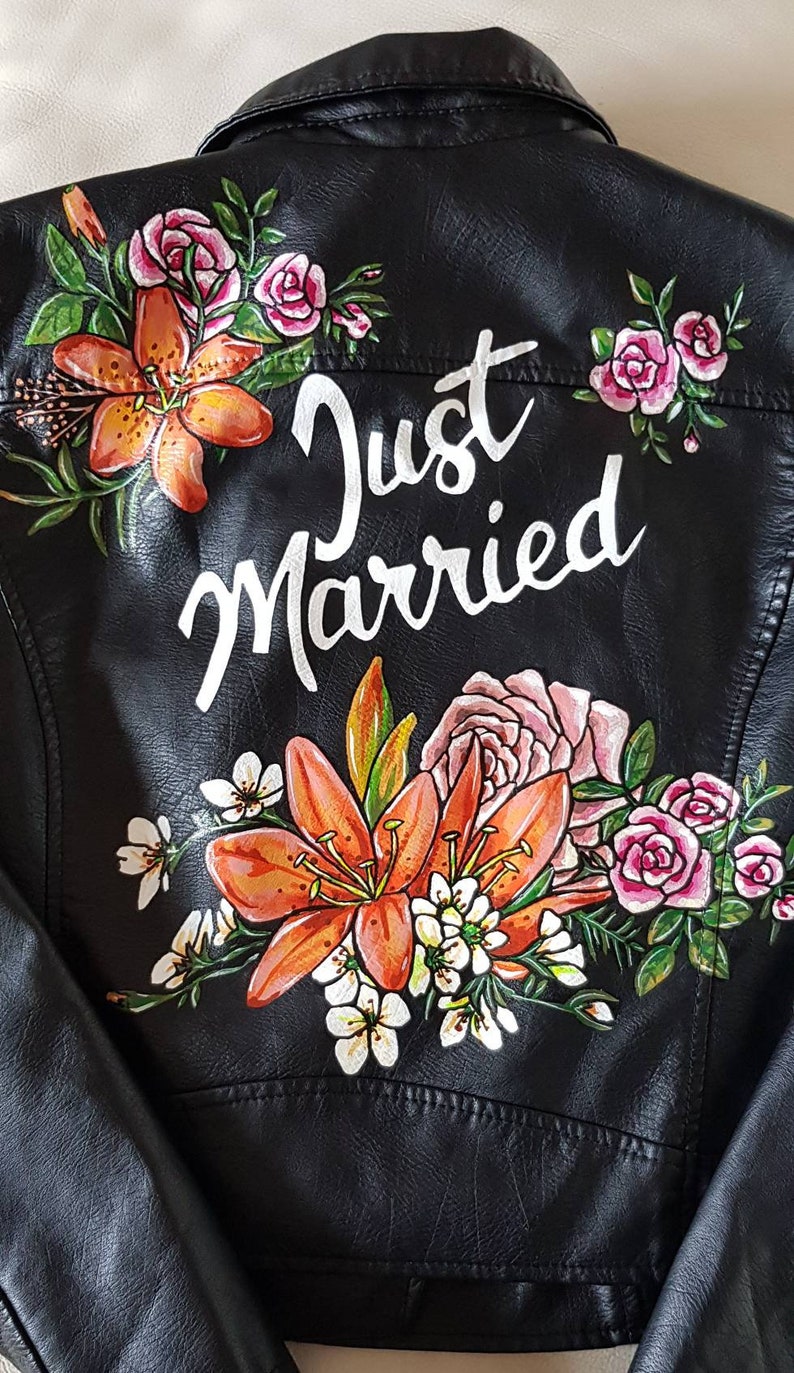 May include: Black leather jacket with a floral design and the words "Just Married" painted on the back.