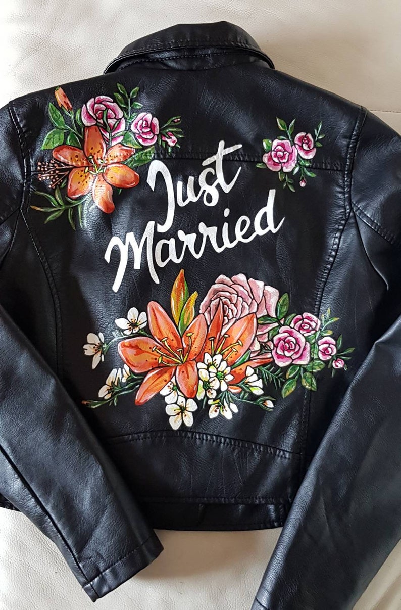 May include: Black leather jacket with a floral design and the words "Just Married" painted on the back.