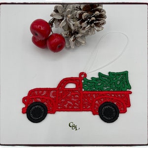 May include: Red lace Christmas ornament shaped like a pickup truck carrying a green lace Christmas tree.