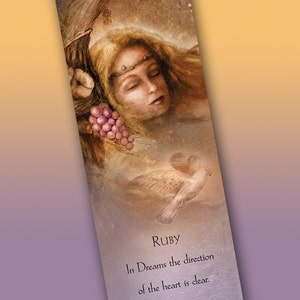 May include: A bookmark with a watercolor illustration of a woman with closed eyes and a crown of flowers. The background is a soft brown and the text reads "RUBY In Dreams the direction of the heart is clear. ~ Inner World Illustration ~ thoughts and dreams shape everything www.innerworldillustration.com © Leanne Peters"