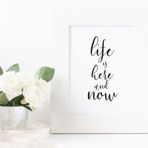 Peut inclure: Impression encadrée blanche avec calligraphie noire qui dit "life is here and now".