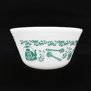 Könnte beinhalten: Weiße Rührschüssel mit grünem Blumen- und Küchenutensilien-Design. Die Schüssel hat ein dekoratives Band mit einer Teekanne, Löffeln und Gabeln. Die Schüssel besteht aus einem strapazierfähigen Material und ist für die Küche geeignet.