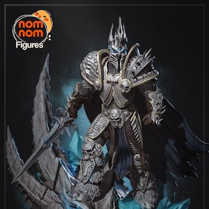 May include: A detailed figure of a warrior in silver and blue armour, holding a sword. The figure stands on a dragon-like structure with blue crystal accents. The figure has a crown and a dark cape. The logo "nom nom Figures" is in the top left corner.