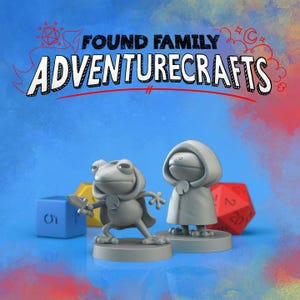 Könnte beinhalten: Blauer Hintergrund mit dem Text "FOUND FAMILY ADVENTURECRAFTS". Zwei graue, froschartige Figuren sind abgebildet, eine davon hält ein Schwert. Würfel in Blau und Rot sind ebenfalls vorhanden.