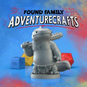 May include: A gray figurine of a cartoonish axolotl holding a spiked club, with the text "FOUND FAMILY ADVENTURECRAFTS" above. Colorful dice are in the background. The axolotl has a crescent moon pendant. The background is a gradient of blue and red.